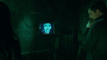 Movie still from “Saw V” (2008), directed by David Hackl – A television with a picture of a face on it; Close Up shot, Over the shoulder angle