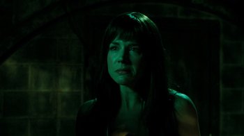 Movie still from “Saw V” (2008), directed by David Hackl – A woman in a dark room with green lighting; Close Up shot, Over the shoulder angle