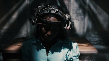 Movie still from “Saw VI” (2009), directed by Kevin Greutert – A woman wearing a head mounted device; Close Up shot, High angle