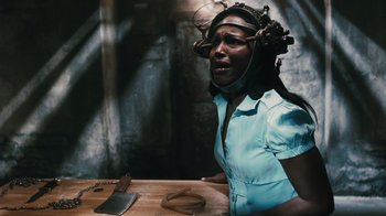 Movie still from “Saw VI” (2009), directed by Kevin Greutert – A woman wearing a blue shirt and a wooden head piece; Close Up shot, Over the shoulder angle