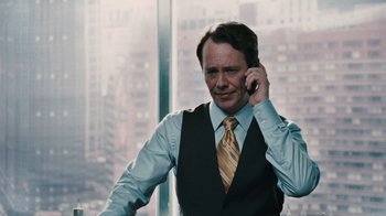 Movie still from “Saw VI” (2009), directed by Kevin Greutert – A man in a vest and tie talking on a cell phone; Close Up shot, Over the shoulder angle