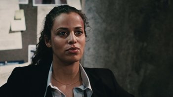 Movie still from “Saw VI” (2009), directed by Kevin Greutert – A person wearing a suit and tie; Close Up shot, Over the shoulder angle