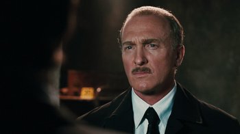 Movie still from “Saw VI” (2009), directed by Kevin Greutert – An older man in a suit and tie looking to his left; Close Up shot, Over the shoulder angle