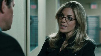 Movie still from “Saw VI” (2009), directed by Kevin Greutert – A woman wearing glasses and a black jacket; Close Up shot, Over the shoulder angle