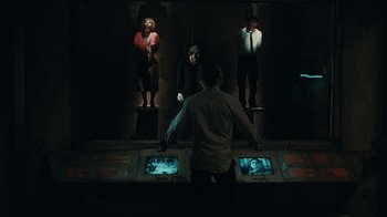 Movie still from “Saw VI” (2009), directed by Kevin Greutert – A group of people standing in front of a screen; Wide shot, Low angle