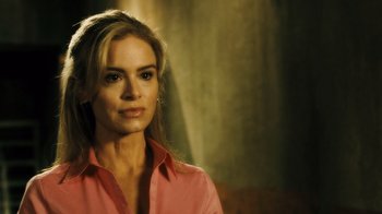 Movie still from “Saw VI” (2009), directed by Kevin Greutert – A woman in a pink shirt is posing for a picture; Close Up shot, Over the shoulder angle