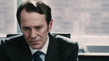 Movie still from “Saw VI” (2009), directed by Kevin Greutert – A person wearing a suit and tie; Close Up shot, Over the shoulder angle