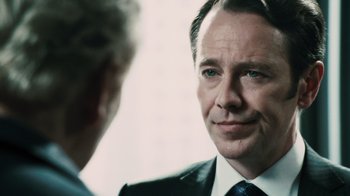 Movie still from “Saw VI” (2009), directed by Kevin Greutert – A person wearing a suit and tie; Close Up shot, Over the shoulder angle