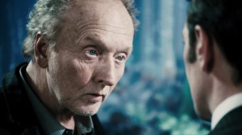 Movie still from “Saw VI” (2009), directed by Kevin Greutert – An older man with blue eyes stares at the camera; Close Up shot, Over the shoulder angle