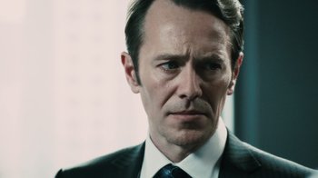 Movie still from “Saw VI” (2009), directed by Kevin Greutert – A person wearing a suit and tie; Close Up shot, Low angle