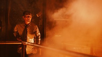 Movie still from “Saw VI” (2009), directed by Kevin Greutert – A man standing in front of a smoke filled room; Medium shot, Low angle