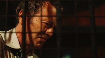 Movie still from “Saw VI” (2009), directed by Kevin Greutert – A person behind a fence; Close Up shot, Low angle