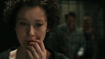 Movie still from “Saw VI” (2009), directed by Kevin Greutert – A person with her hand to her face; Close Up shot, Over the shoulder angle