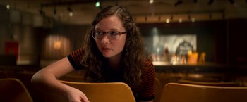 Movie still from “Scary Stories to Tell in the Dark” (2019), directed by André Øvredal – A woman sitting at a table in front of a laptop computer; Close Up shot, Over the shoulder angle