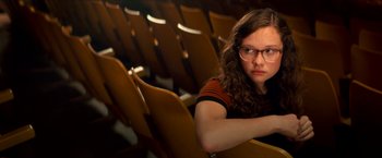 Movie still from “Scary Stories to Tell in the Dark” (2019), directed by André Øvredal – A woman sitting in a row of seats in a theater; Medium shot, High angle