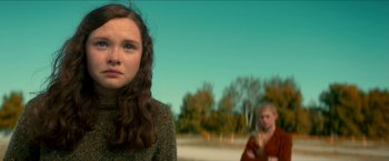 Movie still from “Scary Stories to Tell in the Dark” (2019), directed by André Øvredal – A woman standing next to a man on a field; Close Up shot, Over the shoulder angle