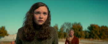Movie still from “Scary Stories to Tell in the Dark” (2019), directed by André Øvredal – A young woman with long hair standing in front of another woman; Close Up shot, Low angle