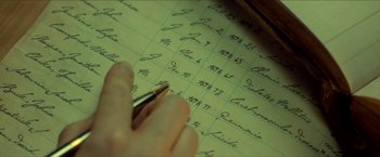 Movie still from “Scary Stories to Tell in the Dark” (2019), directed by André Øvredal – A person writing on a piece of paper; Extreme Close Up shot, High angle