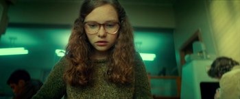 Movie still from “Scary Stories to Tell in the Dark” (2019), directed by André Øvredal – A young girl with glasses is looking at the camera; Close Up shot, Over the shoulder angle