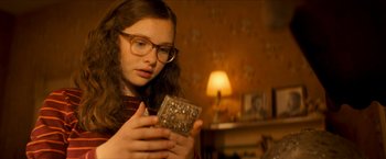 Movie still from “Scary Stories to Tell in the Dark” (2019), directed by André Øvredal – A young girl looking at an antique jewelry box; Close Up shot, High angle
