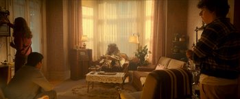 Movie still from “Scary Stories to Tell in the Dark” (2019), directed by André Øvredal – A woman sitting on a chair in a living room; Wide shot, High angle