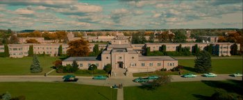 Movie still from “Scary Stories to Tell in the Dark” (2019), directed by André Øvredal – An aerial view of a building with cars parked in front of it; Extreme Wide shot, High angle