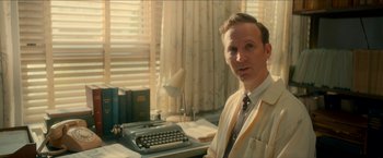 Movie still from “Scary Stories to Tell in the Dark” (2019), directed by André Øvredal – A man sitting in front of an old fashioned typewriter; Medium shot, Low angle