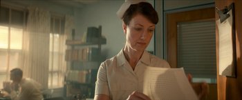 Movie still from “Scary Stories to Tell in the Dark” (2019), directed by André Øvredal – A woman in a nurse's uniform reading a piece of paper; Medium shot, Low angle