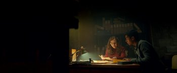 Movie still from “Scary Stories to Tell in the Dark” (2019), directed by André Øvredal – A woman sitting at a desk in a dark room writing; Medium shot, Low angle