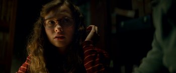 Movie still from “Scary Stories to Tell in the Dark” (2019), directed by André Øvredal – A woman with glasses is looking at the camera; Close Up shot, Low angle