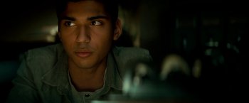 Movie still from “Scary Stories to Tell in the Dark” (2019), directed by André Øvredal – A young man looking into the distance with a serious look on his face; Close Up shot, High angle