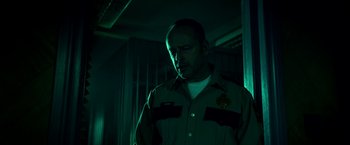 Movie still from “Scary Stories to Tell in the Dark” (2019), directed by André Øvredal – A man wearing a uniform standing in a dark room; Close Up shot, Low angle
