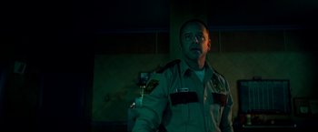 Movie still from “Scary Stories to Tell in the Dark” (2019), directed by André Øvredal – A man in a uniform holding something in his hand; Medium shot, Low angle