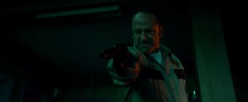 Movie still from “Scary Stories to Tell in the Dark” (2019), directed by André Øvredal – A man is holding a gun in a dark room; Close Up shot, Low angle