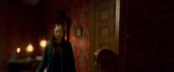 Movie still from “Scary Stories to Tell in the Dark” (2019), directed by André Øvredal – A woman standing in front of a mirror in a room; Extreme Close Up shot, Over the shoulder angle