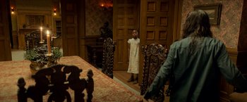 Movie still from “Scary Stories to Tell in the Dark” (2019), directed by André Øvredal – A young girl standing in front of a dining room table; Wide shot, High angle