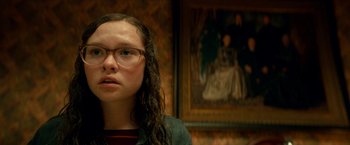 Movie still from “Scary Stories to Tell in the Dark” (2019), directed by André Øvredal – A young woman with long brown hair wearing glasses; Close Up shot, Low angle