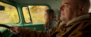 Movie still from “Scary Stories to Tell in the Dark” (2019), directed by André Øvredal – A man and a woman riding in the back of a green truck; Close Up shot, Over the shoulder angle