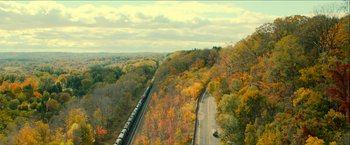 Movie still from “Scary Stories to Tell in the Dark” (2019), directed by André Øvredal – An aerial view of a train traveling through a wooded area; Extreme Wide shot, Overhead angle