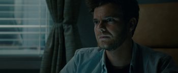 Movie still from “Scream” (2022), directed by Matt Bettinelli-Olpin – A person wearing a shirt; Close Up shot, Over the shoulder angle