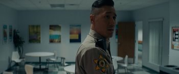 Movie still from “Scream” (2022), directed by Matt Bettinelli-Olpin – A man in a police uniform standing in a room; Close Up shot, Over the shoulder angle