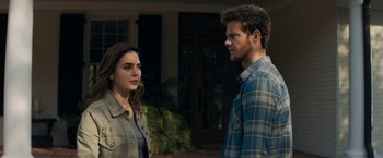 Movie still from “Scream” (2022), directed by Matt Bettinelli-Olpin – A man and a woman standing next to each other outside; Medium shot, Over the shoulder angle