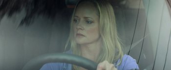 Movie still from “Scream” (2022), directed by Matt Bettinelli-Olpin – A woman sitting in the drivers seat of a car; Close Up shot, Low angle