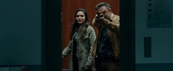 Movie still from “Scream” (2022), directed by Matt Bettinelli-Olpin – A man taking a picture of a woman with a camera; Medium shot, Over the shoulder angle