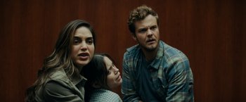 Movie still from “Scream” (2022), directed by Matt Bettinelli-Olpin – Two women and a man sitting next to each other in a room; Close Up shot, Over the shoulder angle