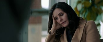 Movie still from “Scream” (2022), directed by Matt Bettinelli-Olpin – A person sitting with her head resting on her hand; Close Up shot, High angle