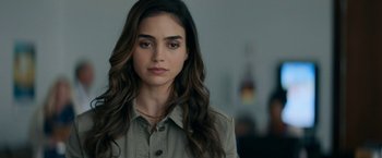 Movie still from “Scream” (2022), directed by Matt Bettinelli-Olpin – A person with long brown hair; Close Up shot, Over the shoulder angle