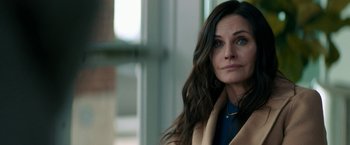 Movie still from “Scream” (2022), directed by Matt Bettinelli-Olpin – A person with long brown hair; Close Up shot, Over the shoulder angle