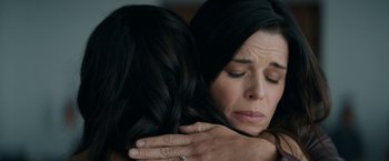 Movie still from “Scream” (2022), directed by Matt Bettinelli-Olpin – A woman is hugging another woman with her hands on her chest; Close Up shot, Over the shoulder angle