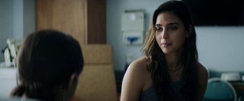 Movie still from “Scream” (2022), directed by Matt Bettinelli-Olpin – A woman sitting in front of a man in a room; Close Up shot, Over the shoulder angle